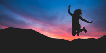 siluet orang yang melompat saat fajar