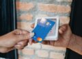 a person handing a credit card to another person